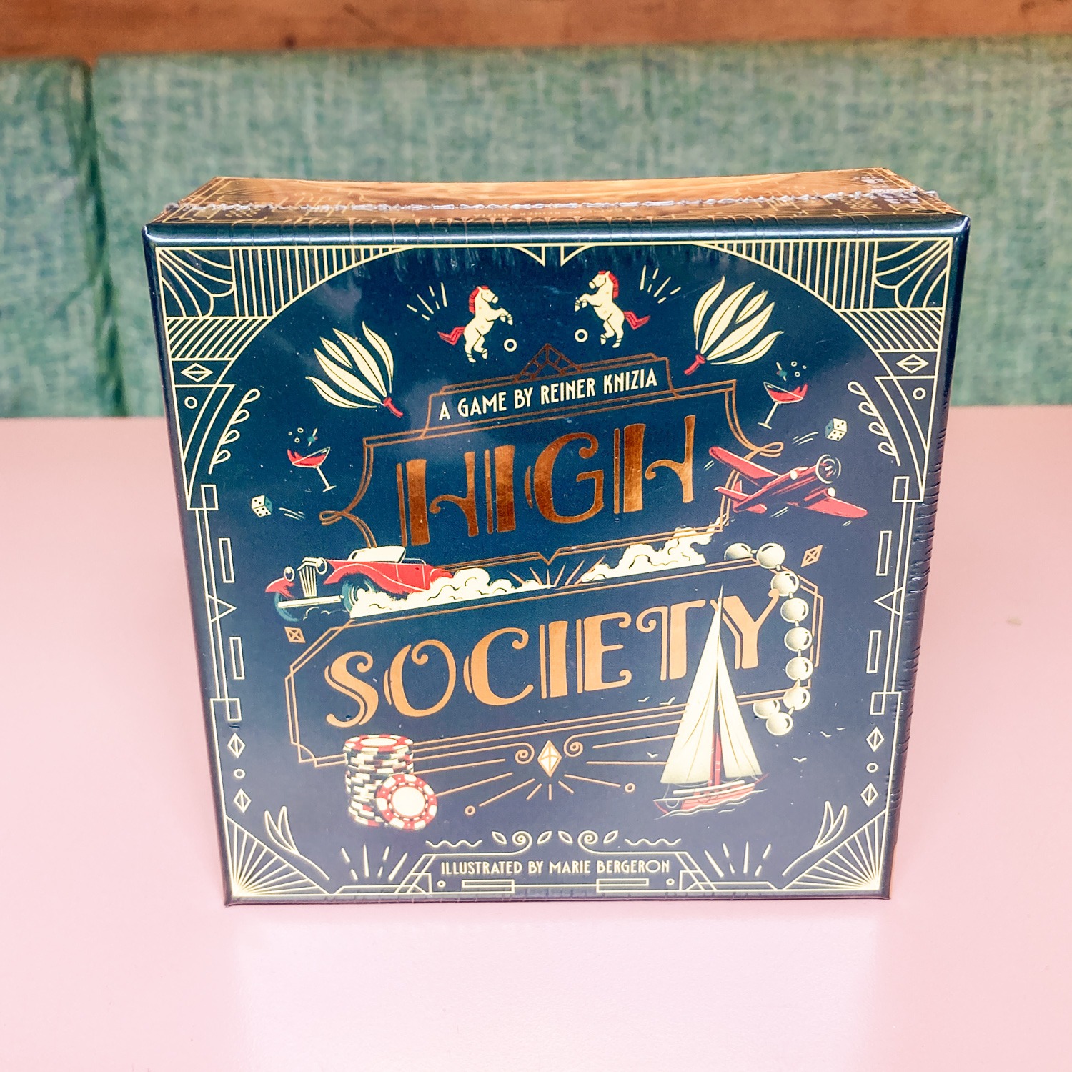 HIGH_SOCIETY_FRONT - Chance & Counters Board game box titled 'High Society' by Reiner Knizia with gold lettering on a dark blue ornate cover.