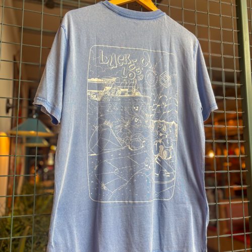 Blue short-sleeve T-shirt on a wooden hanger, displayed against a wire grid background with a light, graphic print on the chest area (informative display)