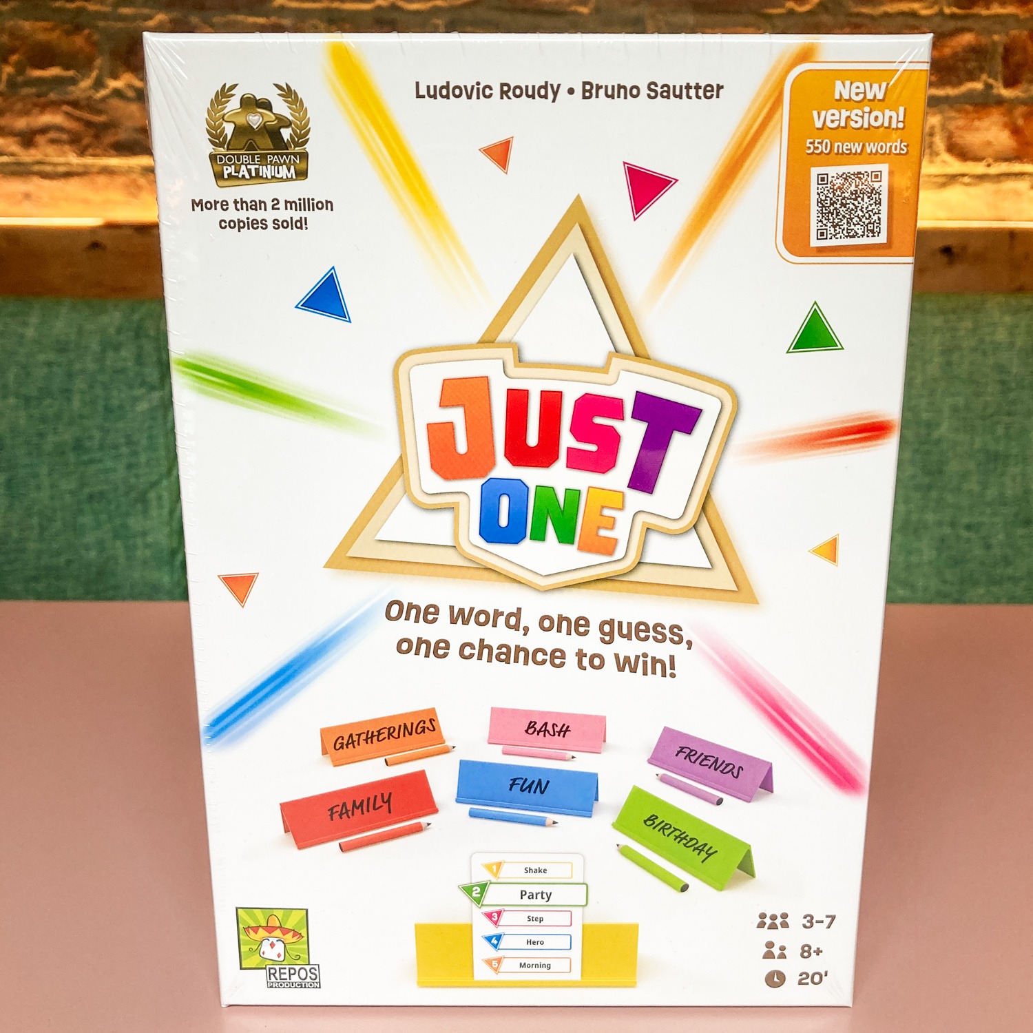 JUST_ONE_FRONT - Chance & Counters Front of the Just One game box with a colorful rainbow logo, triangle shapes, and the subtitle 'One word, one guess, one chance to win.'