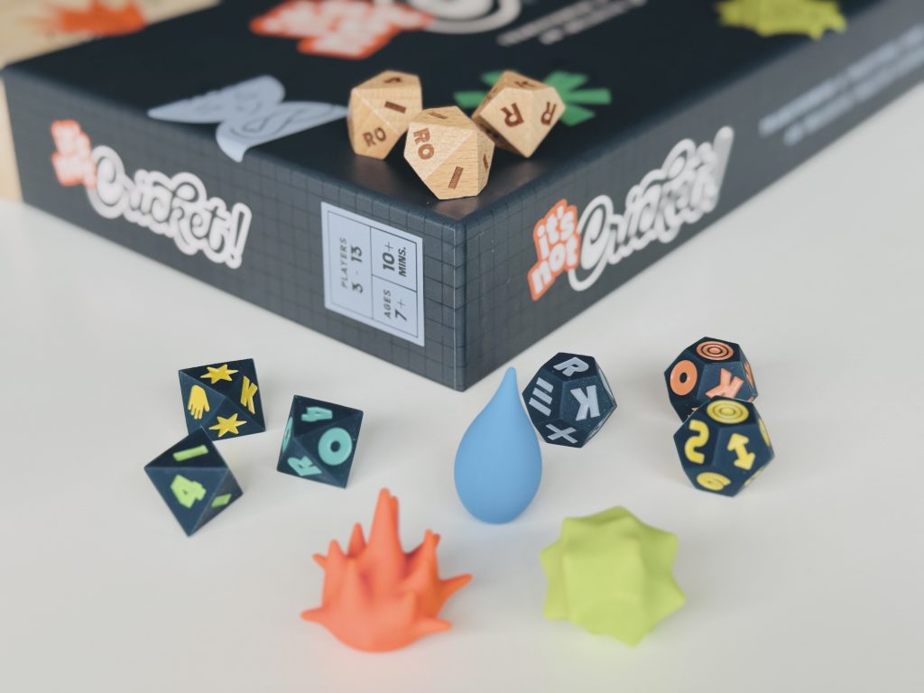 dice - Chance & Counters Assorted dice and colorful game tokens scattered on a dark board game box.